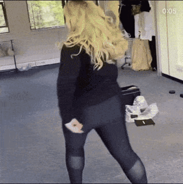 a woman is dancing in a room with the time of 0:05 on the bottom