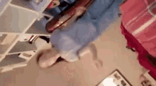 a person is standing on their head in a room with a shelf in the background .