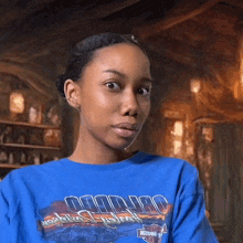 a woman in a blue harley davidson shirt looks at the camera