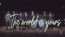 a group of men are standing in front of a sign that says the world is young