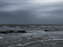 a stormy sea with waves crashing on the shore
