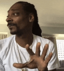 snoop dogg is wearing a white shirt and a necklace