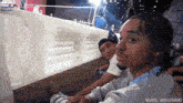 two men are sitting next to each other and one has a phone in his hand .