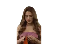 a woman in a pink top is looking into her wallet