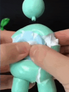 a person is holding a toy with a balloon on its head .