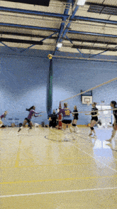 a volleyball player wearing a number 18 jersey runs towards the net