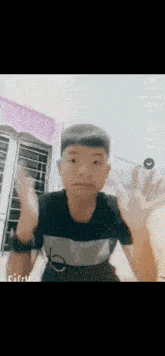 a young boy is making a funny face while waving his hands .