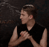 a man holds his hands together in front of a dragon sign