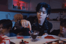 a man wearing a black jacket with the word re on it is pouring something into a glass