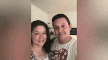 a man and a woman are posing for a picture together .