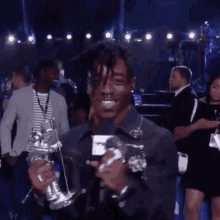 a young man is holding a trophy and smiling at the camera .