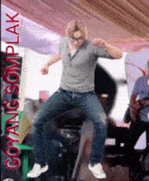 a man is jumping in the air with the words goyang somplak in red