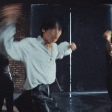a man wearing a white shirt is dancing with his arms outstretched