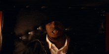a man is laying on a black leather couch with his mouth open
