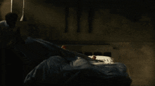 a shirtless man is lifting a barbell in the dark