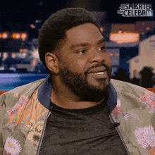 a man with a beard is wearing a jacket that says ' are you smarter than celebrity '