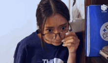 a girl wearing glasses and a shirt that says the