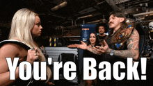a man and a woman are standing next to each other with the words " you 're back " behind them