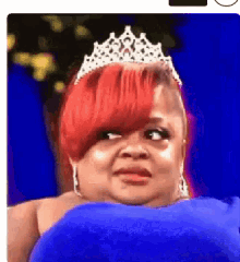 a woman with red hair wearing a tiara and a blue dress
