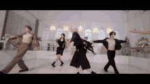 a group of people are dancing in a room