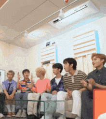a group of young men sit on a couch in a room