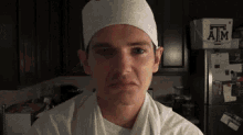 a man wearing a chef 's hat stands in front of a box that says atm on it