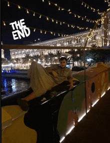 a man laying on a boat with the end written on the bottom right