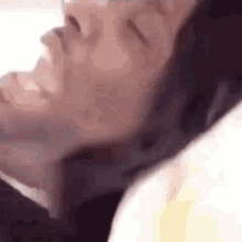a close up of a man 's face with his eyes closed .