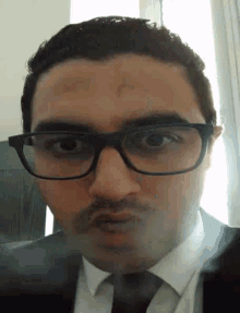 a man with glasses and a mustache is making a face