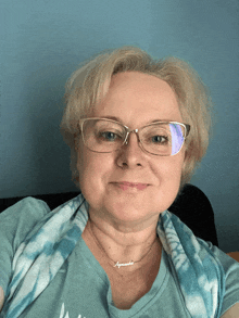 a woman wearing glasses and a necklace that says agnieszka