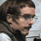 a close up of a man wearing glasses and a vest that says nayrenshaw on it
