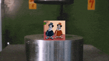 a picture of two cartoon characters is being pressed against a metal cylinder