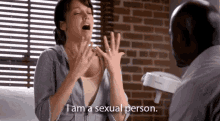 a woman is sitting in front of a man and says i am a sexual person .