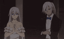 a woman in a white dress and a man in a tuxedo are standing next to each other