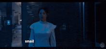 a woman in a white top stands in a dark room with the words " snail react " below her