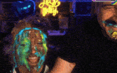 a man and a woman with their faces covered in paint and a sign that says " love party "