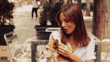 a woman sitting at a table petting a dog