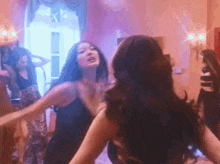 a group of women are dancing together in a room with purple lights .