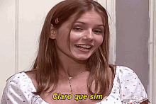 a woman is smiling with the words claro que sim written on her face