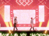 two men are standing on a stage with their hands in the air .