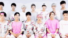 a group of young men are posing for a picture while wearing floral shirts .