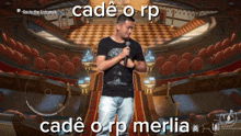 a man holding a microphone in front of an empty auditorium with the words cadé o rp on the bottom right