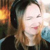 a woman wearing headphones is smiling and making a face