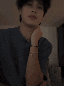 a man wearing a necklace and a bracelet with the letter a on it