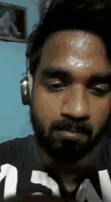 a man with a beard is wearing headphones and a shirt that says ' n ' on it