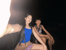 a girl in a blue tank top sits next to a boy wearing a jersey that says ' tcf ' on it