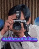 a man is taking a picture with a camera and the words " assalamualaikum " on the bottom right