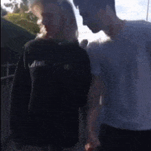 a man and a woman are standing next to each other holding hands