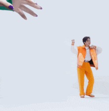 a man in orange pants and an orange jacket is dancing