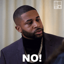 a man wearing a suit and turtleneck says no